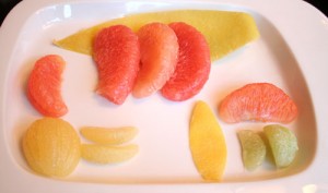 Some assorted citrus: Red pomelo with peel, grapefruit, lime, lemon peel, lemon.